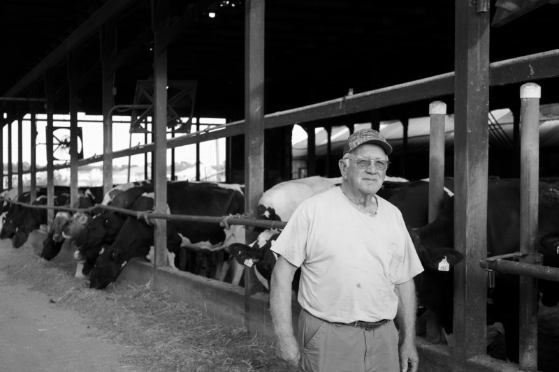 Emerson Hickey’s black-and-white shot of a dairy farmer and cows took second place in the 2025 DEFB photo contest.